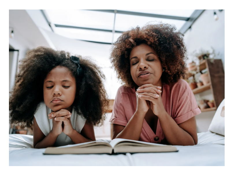 a child and mom lying down and praying