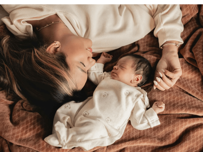 a mom lying in bed with her newborn