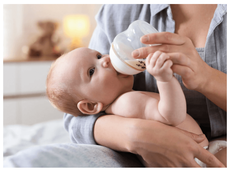 a mom feeding her baby a bottle
