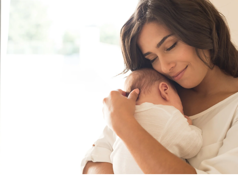 a newborn mom carrying her baby on her chest